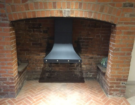 Inglenook canopy in steel with brass stud detailing.